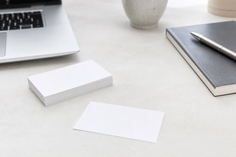 Scrivania ordinata con monitor acceso, mouse bianco e cuffie senza fili accanto alla tastiera