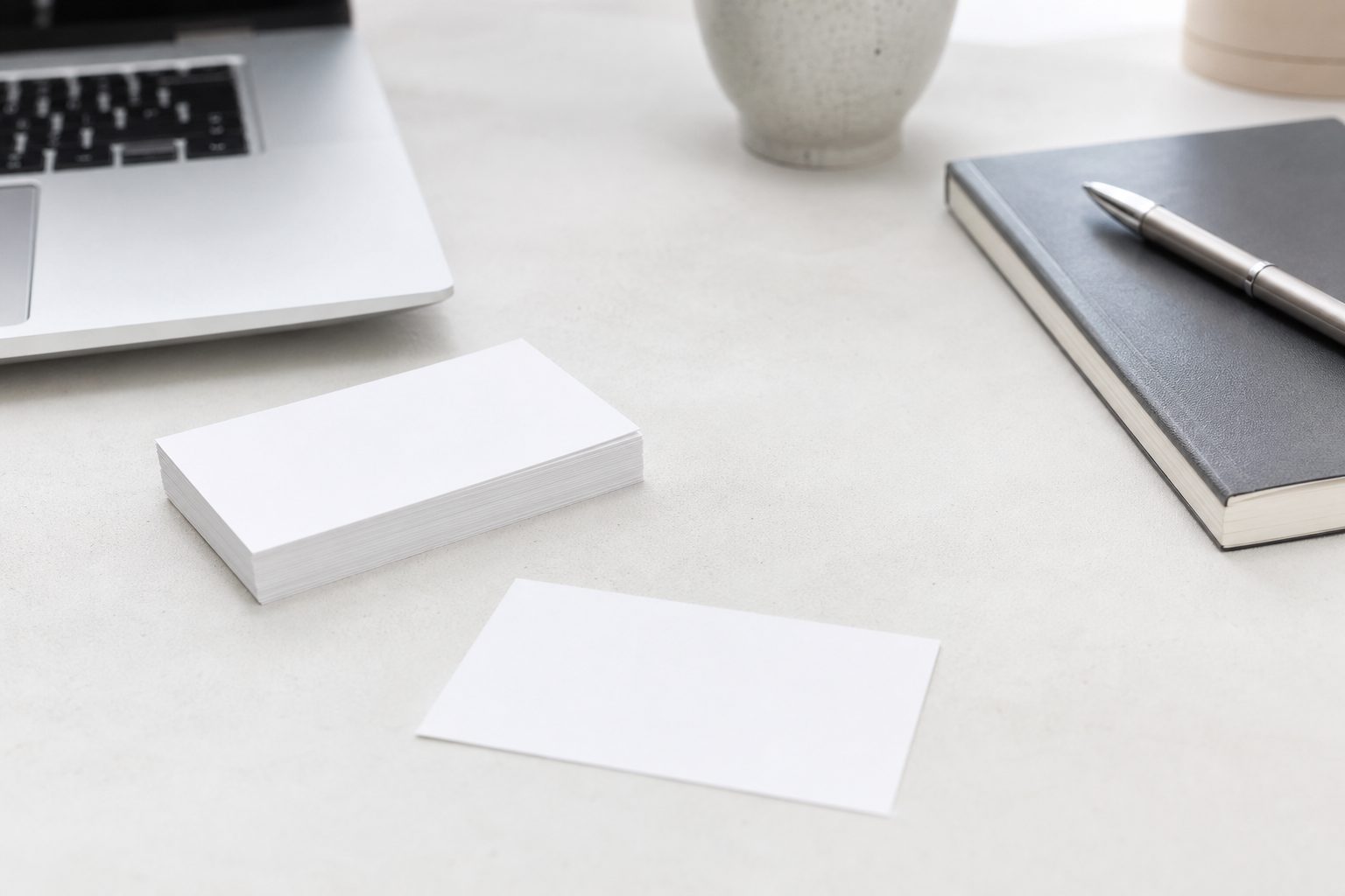 Scrivania ordinata con monitor acceso, mouse bianco e cuffie senza fili accanto alla tastiera